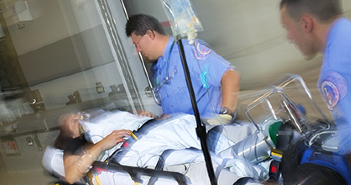 Paramedics wheel a patient into a hospital on a gurney