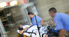 Paramedics wheel a patient into a hospital on a gurney